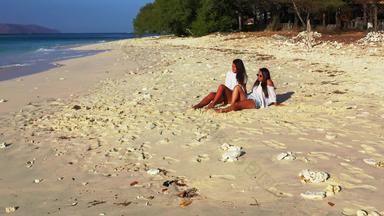<strong>性感</strong>的快乐女士们拍的有趣的海滩阳光明媚的蓝色的白色沙子背景